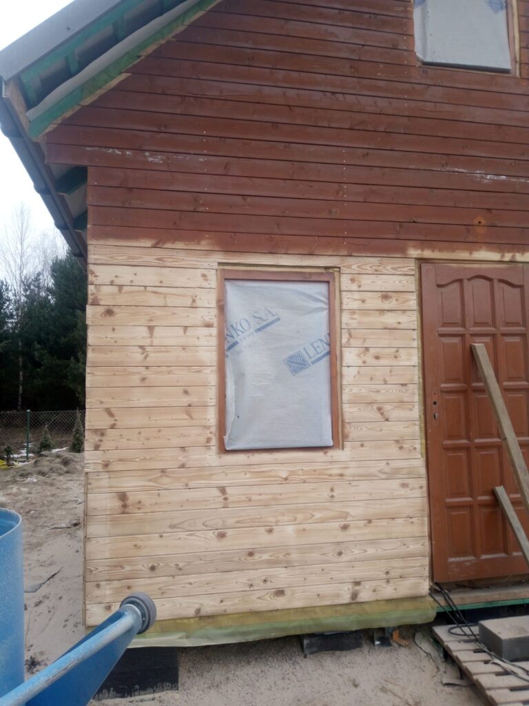 Domek drewniany częściowo wypiaskowany, pokazujący różnicę między starą powłoką a odświeżonym drewnem – Olsztyn